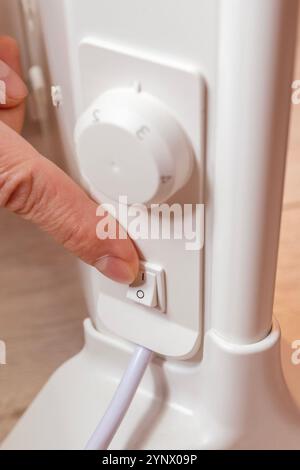 Energy saving. Switch off button of the electrical appliance. Finger on the button close-up Stock Photo