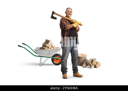 Mature man with a wheelbarrow holding an axe on his shoulder isolated on blue background Stock Photo