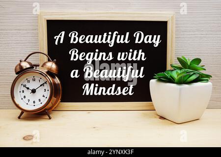 A Beautiful Day Begins With A Beautiful Mindset Motivational And Inspiration Quotes with alarm clock on wooden background Stock Photo