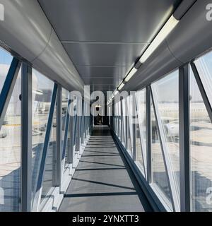 Empty passenger boarding bridge leading to an aircraft at an airport Stock Photo