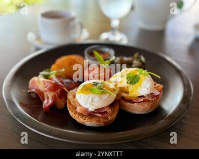 Eggs Benedict with extra bacon, hash browns, baked beans and tomato Stock Photo