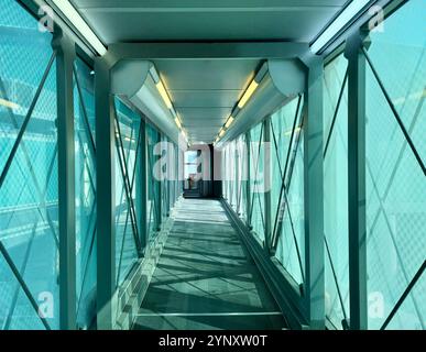 Empty passenger boarding bridge leading to an aircraft at an airport Stock Photo