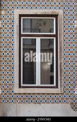 A decorative blue and white tiled wall showcases a modern window design. Stock Photo
