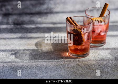 Close-up of two cherry cocktails with cinnamon sticks and dried orange slices Stock Photo
