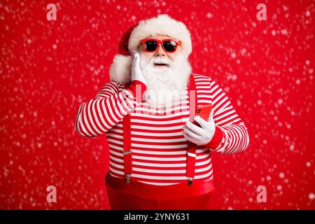 Portrait of his he nice handsome attractive cheerful amazed delighted bearded fat Santa using device app 5g browsing shopping isolated on bright vivid Stock Photo