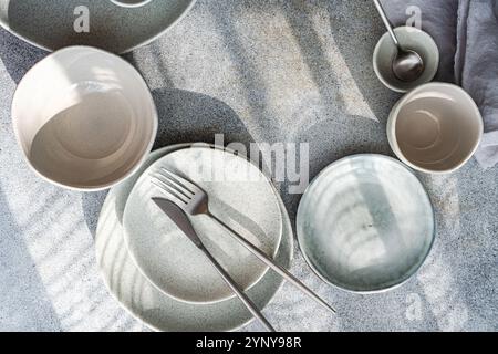Overhead view of assorted ceramic crockery and cutlery on a table with napkins Stock Photo
