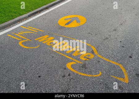 Italy - November 27, 2024: McDrive logo drawn in yellow on road asphalt with indication arrow, McDrive is a McDonald's service Stock Photo