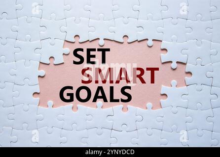 Set smart goals symbol. Concept words Set smart goals on white puzzle. Beautiful pink background. Business and Set smart goals concept. Copy space. Stock Photo