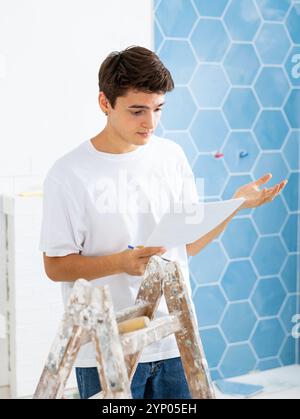 Confused young designer determining scope of work in apartment during refurbishment Stock Photo