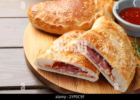 Pieces of calzone pizza served on wooden table, closeup Stock Photo