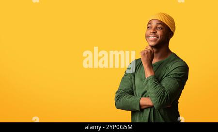 Good Offer. Pensive Young African-American Guy Looking At Copy Space With Interest Stock Photo