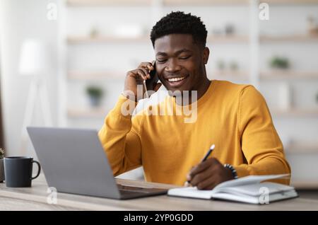 Happy black man freelancer working from home Stock Photo