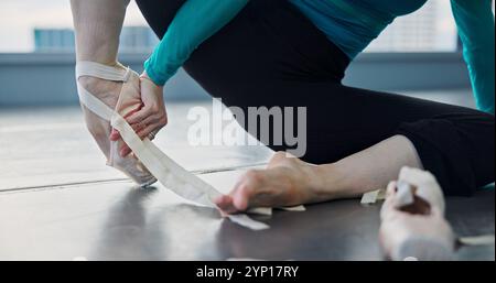 Stretching, legs and dancer in studio, hands and warm up for ballet, healthy and preparing for performance. Fitness, wellness and balance for Stock Photo