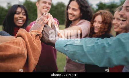 Young multiethnic group of people stacking hands together outdoor ...