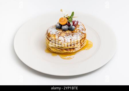 Pancakes with fruit and maple syrup on a white plate Stock Photo