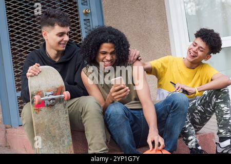 teen friends having fun sharing mobile phone Stock Photo