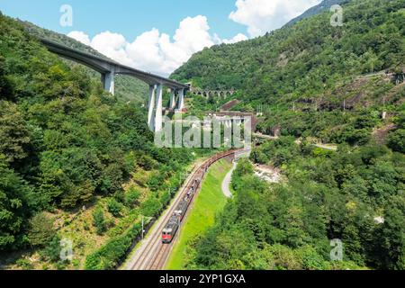 Giornico, Switzerland - August 28, 2024: Freight train of SBB Cargo on Gotthard railway in the Swiss Alps aerial view photo in Giornico, Switzerland. Stock Photo