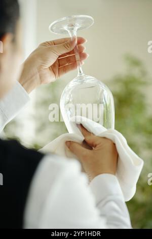 Polishing Stemware in Bright Kitchen Setting Stock Photo