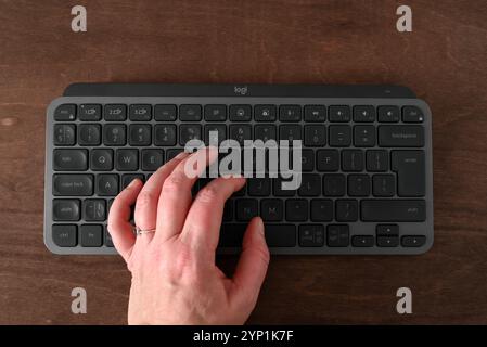 Lublin, Poland November 20 2024 a female hand on a wireless Bluetooth portable computer or tablet keyboard Logitech NX Mini Stock Photo