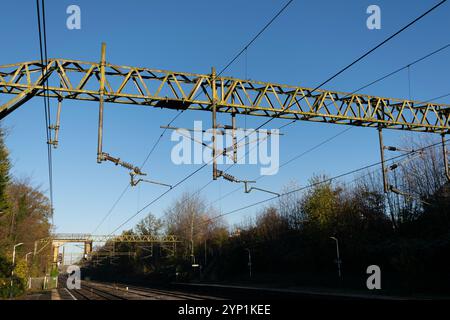 Rail electrification. Overhead rail power lines on the West Coast Main Line, Manchester, UK. Blue sky over railway. Stock Photo