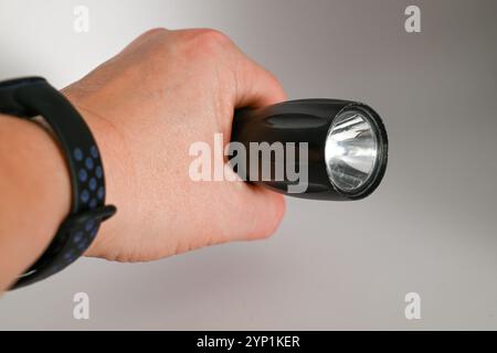 hand holding well used small but powerful flashlight or electric torch Stock Photo