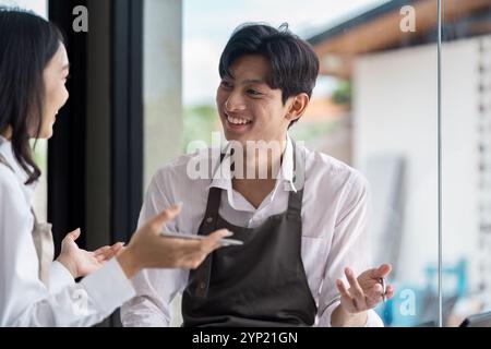 Young Professionals Engaged in a Productive Business Meeting in a Modern Office Setting with Natural Light and Collaborative Atmosphere Stock Photo