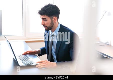 Businessman working on laptop in modern office during working hours. Stock Photo