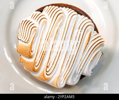 Round small cake with white cream on plate, top view Stock Photo