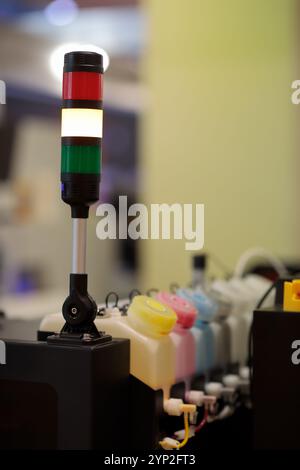 Industrial tower signal lights mounted on large format inkjet printer. LED signal stack lights. Selective focus. Stock Photo