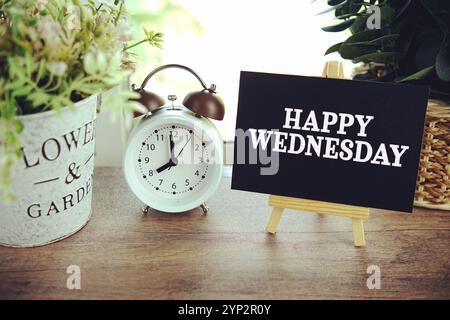 Happy Wednesday text on paper card with ealsel on wooden background Stock Photo