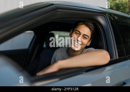 Portrait of happy young man sitting in car Stock Photo