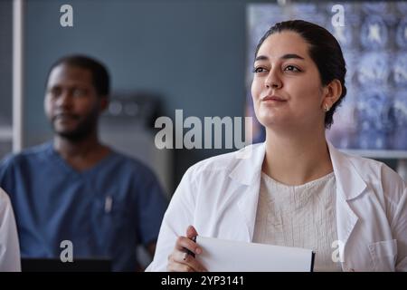Portrait of of smiling Middle Eastern woman attending lecture at conference room taking continuing learning course for neurologists at hospital, copy Stock Photo