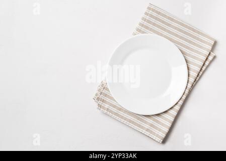 Empty white plate with napkin on white background, top view, copy space. Food design template, catering meal mock up. Stock Photo