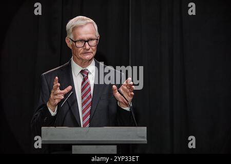 Medium shot of senior politician in suit giving public speech announcing law to residents while standing at podium on stage during press conference ag Stock Photo