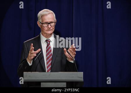Medium shot of senior politician in formal attire giving public speech announcing legislative initiative during press conference while standing at pod Stock Photo