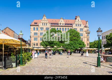 Tourists stroll on the Lilla Torg, a cobbled square in the old town of Malmö, Sweden, lined with sidewalk cafes and restaurants, on a sunny summer day Stock Photo