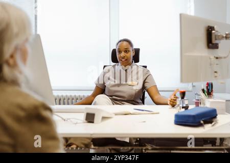 Female medical practitioner talking with patient in clinic at hospital Stock Photo