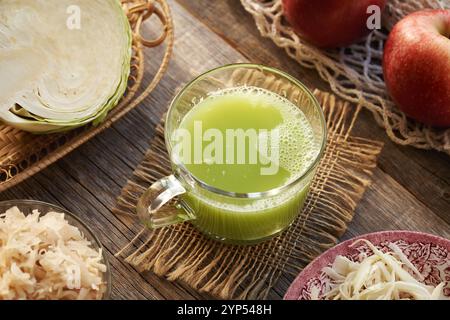 A cup of green cabbage juice with cucumber and apples on a table Stock Photo