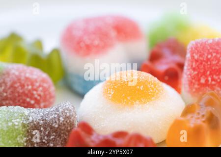 detail studio shot of a pile of multicolored jelly beans and sweets of various shapes and sizes on a clean white background. Concept of sweet colorful Stock Photo