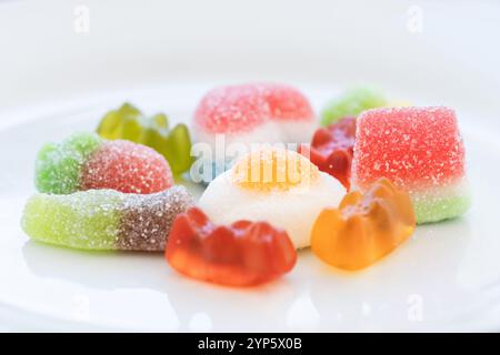 studio shot of a pile of multicolored jelly beans and sweets of various shapes and sizes on a clean white background. Concept of sweet colorful world, Stock Photo