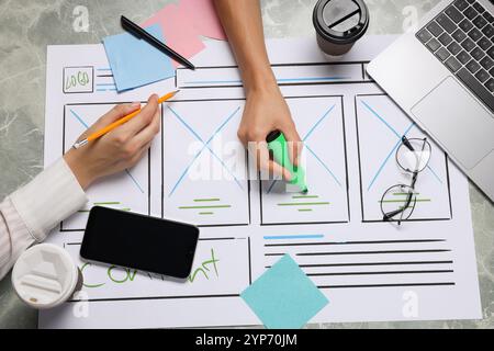 Developing UI design. Designers creating website wireframe on paper at grey marble table, top view Stock Photo
