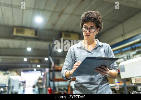 Caucasian adult woman checking quality of products in a cnc metallurgic factory Stock Photo