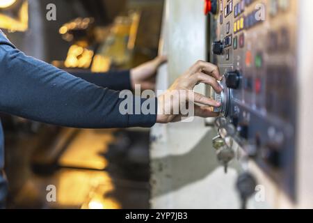 Side view of the hands of a male caucasian worker using control panel of lathe machine in cnc factory Stock Photo