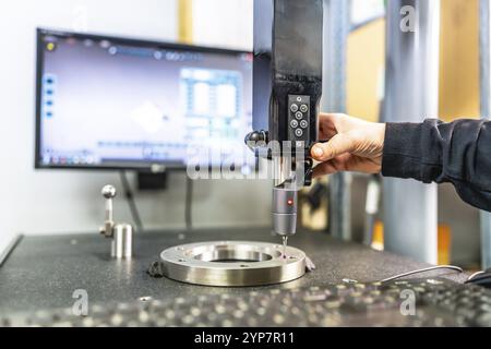 Close-up of the hand of a technician working with three-dimensional verification and measuring machine in a cnc innovative metal factory Stock Photo