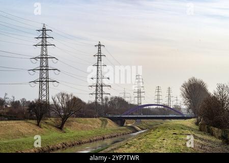 High-voltage pylons with sewer and road bridge Stock Photo