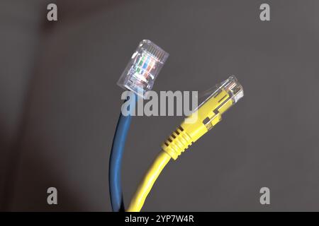 In this photo illustration, two internet network cables, one blue and one yellow Stock Photo