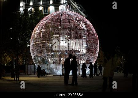 Madrid, Madrid, Spain. 28th Nov, 2024. A couple kisses in front of a huge Christmas ball with lights, in the center of Madrid, during the switching on of the Christmas lights by the Madrid City Hall. (Credit Image: © Luis Soto/ZUMA Press Wire) EDITORIAL USAGE ONLY! Not for Commercial USAGE! Stock Photo