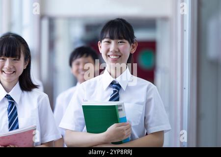 Junior high girl students walking in library Stock Photo - Alamy
