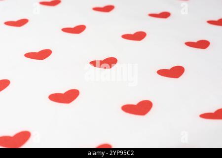 pattern of red cute hearts on white fabric textured surface, love romantic and valentines day decoration, soft focus with blurry background Stock Photo