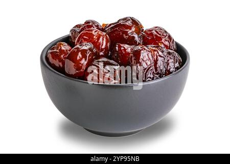 Pile of sweet pitted chinese jujube fruit preserved in syrup in black ceramic bowl isolated on white background with clipping path. Stock Photo